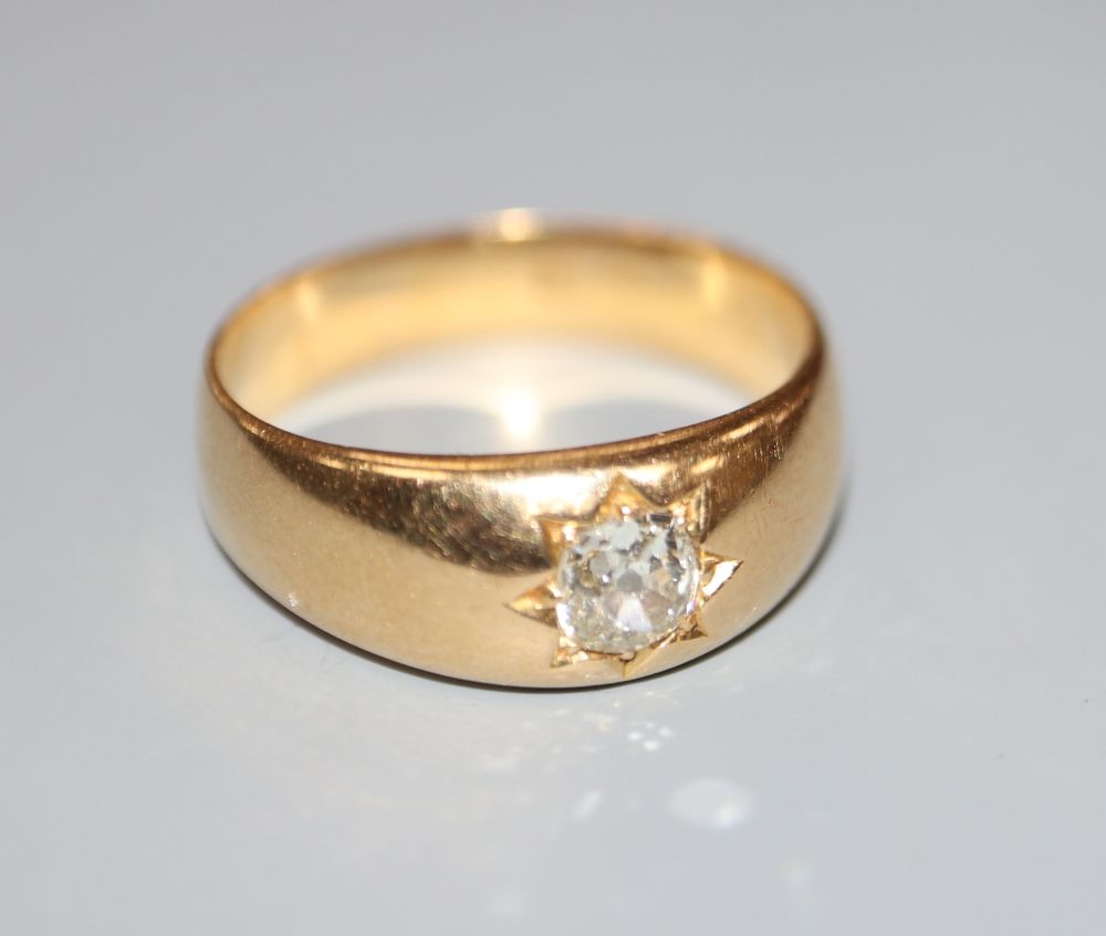 A late Victorian yellow metal and gypsy set solitaire diamond ring, size R, gross 7 grams.